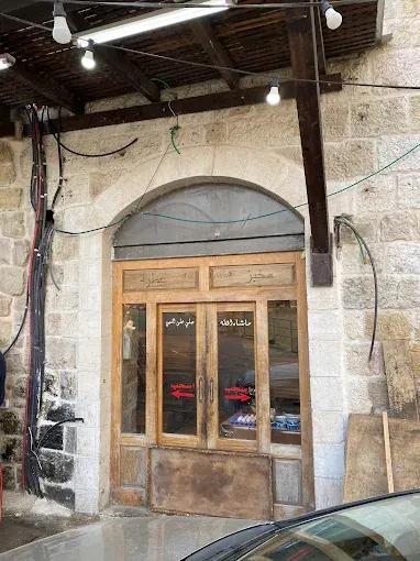 مدخل مخبز البلد بباب خشبي وجدران حجرية قديمة